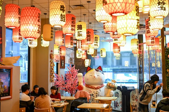 Red and yellow lanterns list the names of some of the restaurant’s most popular dishes.