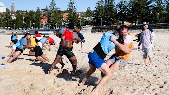 Wallabies forwards bash each other in one-on-one wrestling drills.