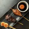 A platter with tsukune (chicken meatball), wagyu and scallop skewers at Robata.