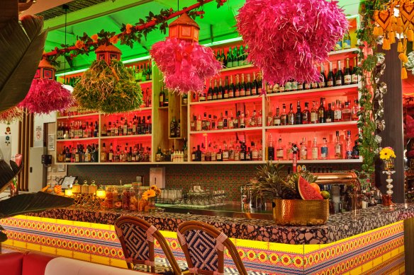 The bar is a striking mix of pink garlands, floral patterns, and contrasting colours.