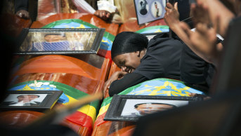 Relatives grieve next to empty caskets draped with the national flag at a mass funeral at the Holy Trinity Cathedral in Addis Ababa, Ethiopia on Sunday.