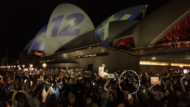 Protesters on the harbour foreshore opposing the projection of material, promoting the 2018 Everest Horse Race onto the sails of the Opera House.