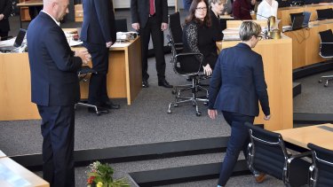 Die Linke's Susanne Hennig-Wellsow, right, walks away from Thomas Kemmerich of the Free Democrats, after throwing a bouquet of flowers in front of him, in Erfurt, Germany.