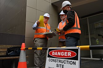 NSW Building Commissioner David Chandler, left, talks about the removal of cladding from a Darlington apartment building.