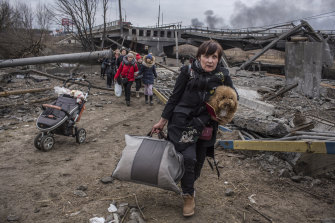 週日，人們在逃離烏克蘭伊爾平鎮時穿過一座被毀壞的橋下的臨時小路。