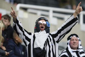 A Newcastle United fan celebrates the side’s first home match since a Saudi-backed takeover last month.