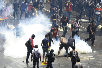 Des manifestants tentent de retirer un obus de gaz lacrymogène après qu'il a été tiré par la police pour les disperser à Colombo, au Sri Lanka.