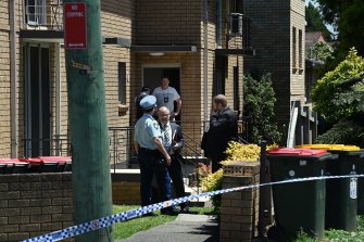 Officers in front of an apartment block where a police officer was injured.  