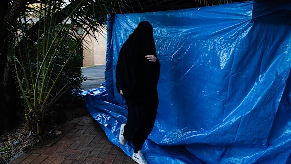 A woman returns to the house in Chiswick Street, Greenacre, where Isaak el Matari lives, on Tuesday afternoon.