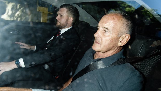 Chris Dawson is driven to Surry Hills police station on Thursday morning, accompanied by Detective Senior Constable Daniel Poole.