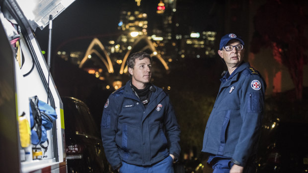 Reverend Paul McFarlane, right, senior chaplain for NSW Ambulance service, speaks with Duty Ops Manager, Andrew Rienits, Special Ops Team Leader, at the scene of a siege in Kirribilli. 