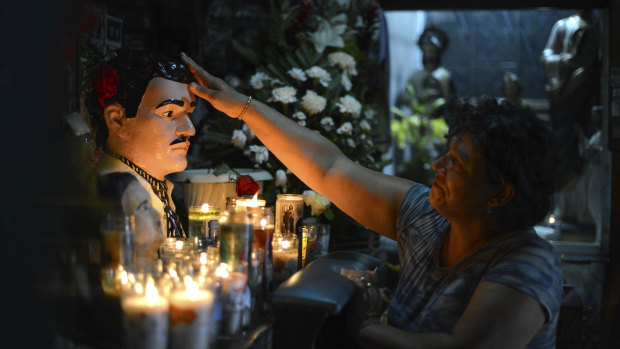A woman prays to the folk saint Jesus Malverde in Culiacan, the capital of Sinaloa state in Mexico. 