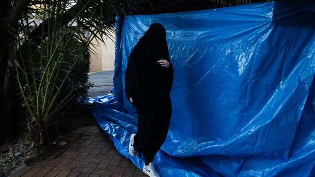 A woman returns to the house in Chiswick Street, Greenacre, where Isaak el Matari lives, on Tuesday afternoon.