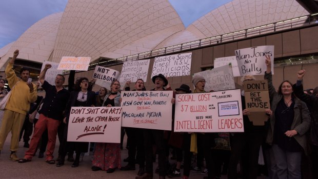 Protesters on the harbour foreshore opposing the projection of promotional material onto the Opera House sails.