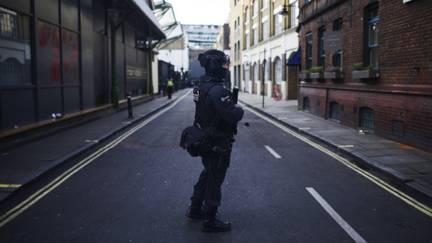 An armed police officer stands guard near the scene.