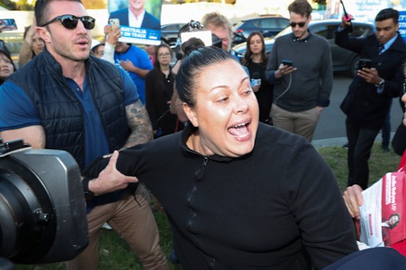 The protester was held back as the PM passed.