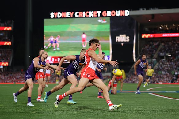 Charlie Curnow of the Swans gets his kick away