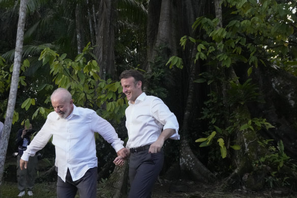 Brazilian President Luiz Inacio Lula da Silva, left, and French President Emmanuel Macron arrive on Combu Island, Para state, Brazil, on Tuesday. The image was co-opted by memes poking fun at their “very close” relationship.