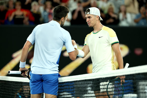Novak Djokovic and Dino Prizmic meet at the net after their unexpectedly tight first-round encounter.