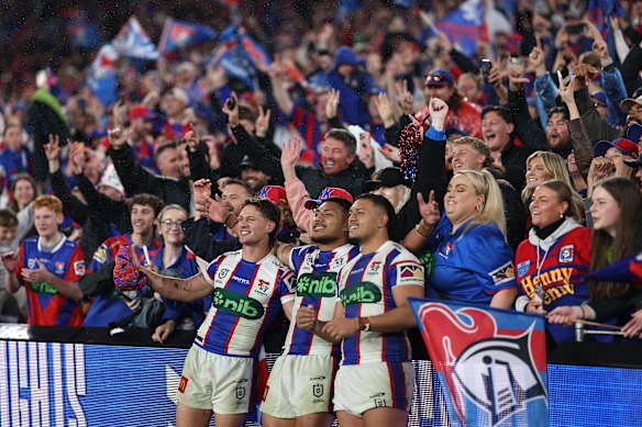 Kalyn Ponga, Francis Manuleleua and Jermaine McEwen celebrate with Newcastle fans on Sunday. 