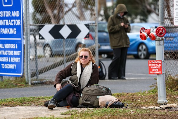 A stranded passenger waits outside the airport.