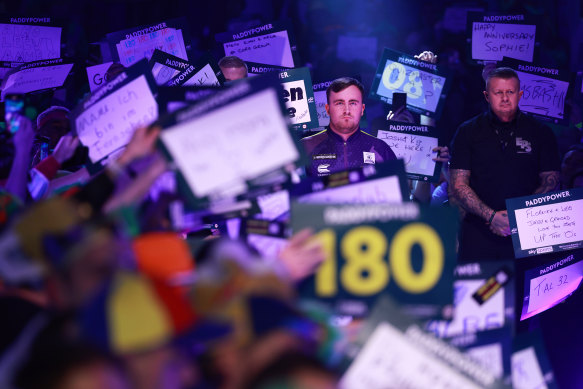 Luke Littler walks to the stage for a match at the World Darts Championships at London’s Alexandra Palace.