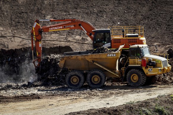 Workers clean up the Barro Landfill after a fire.