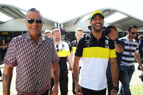 Singer Robbie Williams walks through the paddock with F1 driver Daniel Ricciardo days before the 2020 grand prix was cancelled.