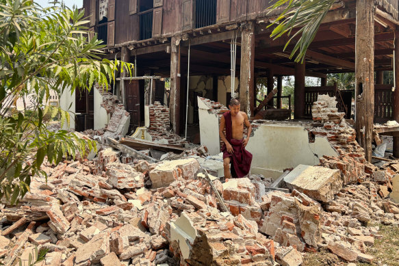 A Buddhist monk walks near a damaged building at a monastery compound in Naypyitaw, Myanmar.