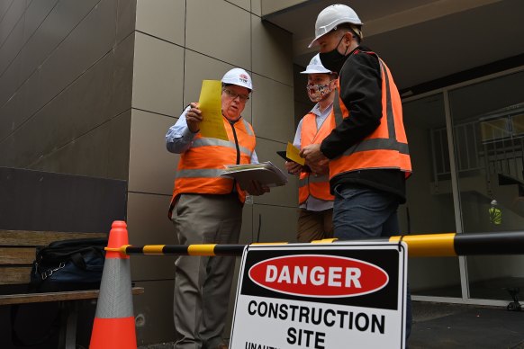 NSW Building Commissioner David Chandler, left, talks about the removal of cladding from a Darlington apartment building.