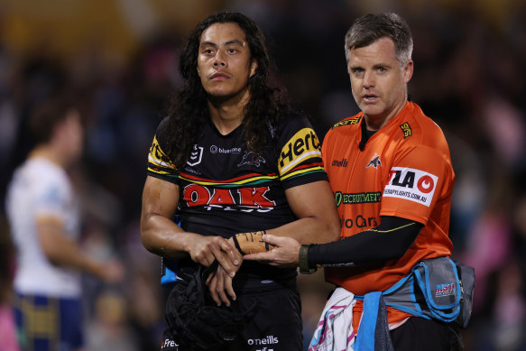 Jarome Luai leaves the field with Panthers physio Pete Green last week