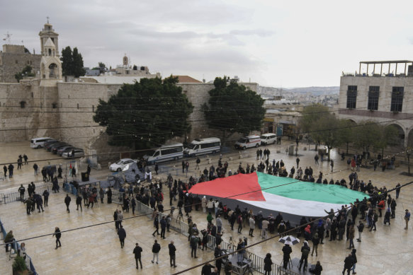 The flag of Palestine is unfurled on Manger Square near the Nativity Church in Bethlehem. The church is said to be the birthplace of Jesus.