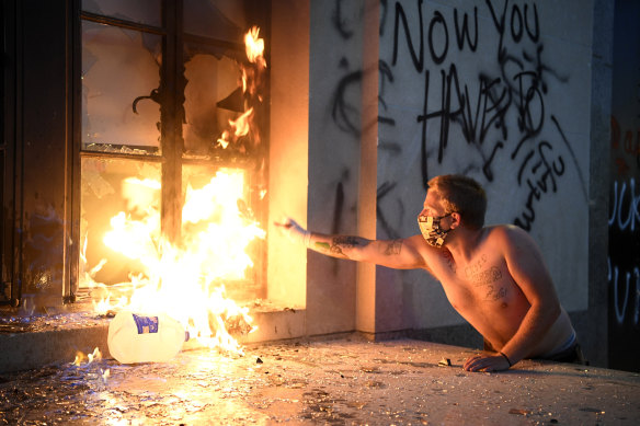 A protester starts a fire at the Metro Courthouse in Nashville, on Saturday.