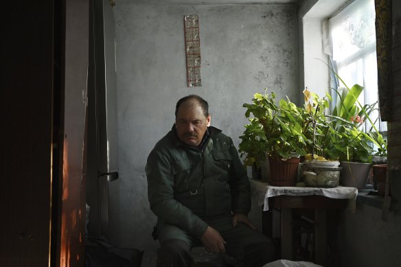 Volodymyr Kmitevych sits among his wife’s plants.
