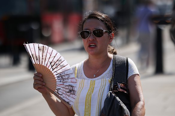 A woman using a fan in London on June 26, the day the London School of Economics cancelled its event on extreme heat.