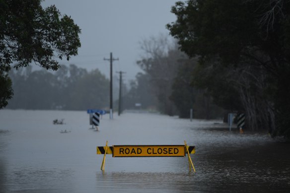 A road closed sign stands in floodwaters on the Coolangatta Road at Far Meadow in the Shoalhaven area.