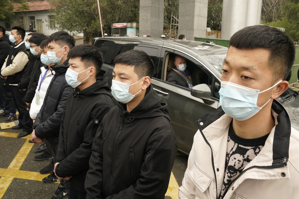 Peter Daszak of the World Health Organization leaves in a car past a row of security personnel at the Hubei Centre for Disease Control and Prevention in Wuhan.