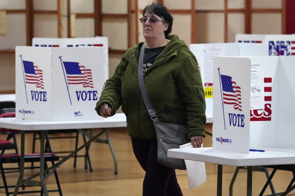 A resident, with ballot in hand, walks towards a ballot reader in Auburn, New Hampshire.