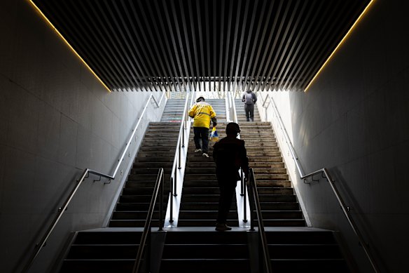 A Meituan rider climbs a set of stairs to deliver takeaway to a customer. 