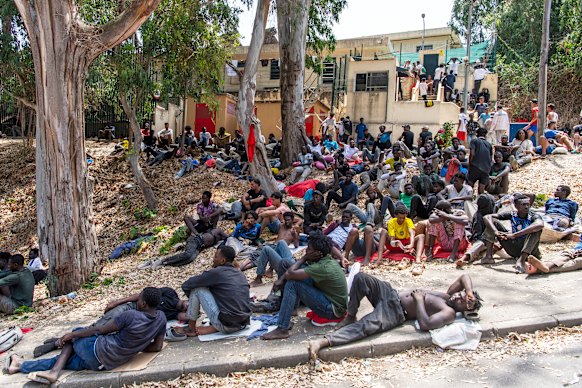 Migrants rest outside the Temporary Centre for Immigrants (CETI) after crossing from Morocco.