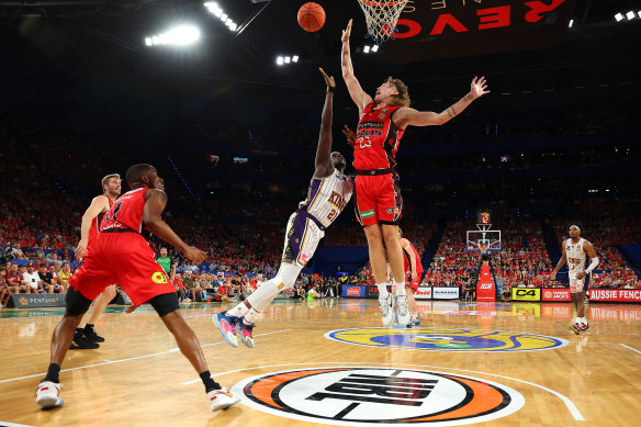 Luke Travers of the Wildcats blocks a shot by Kouat Noi.