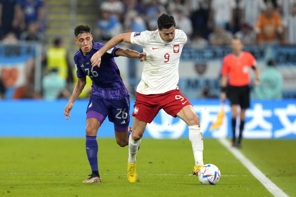 Poland’s Robert Lewandowski, right, is challenged by Argentina’s Nahuel Molina.