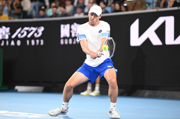 John Millman returns the ball to Daniil Medvedev.