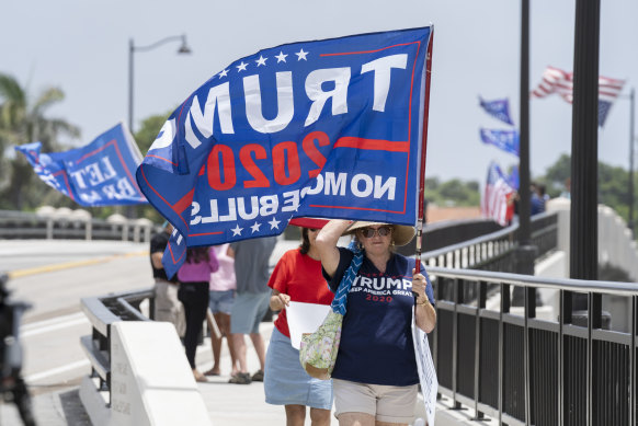 It’s not the scepticism of the right, but the willingness to believe anything. Trump supporters carry flags near Mar-a-Lago in Palm Beach, Florida.
