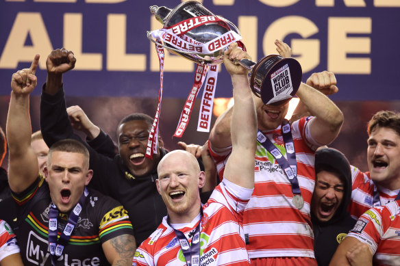 Liam Farrell lifts the trophy for Wigan.