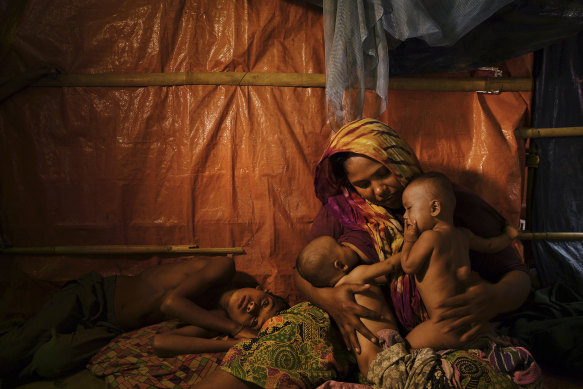 Fatima Begum comforts her twins as her 9-year-old son lays at her side in Cox’s Bazar, Bangladesh, 2018.