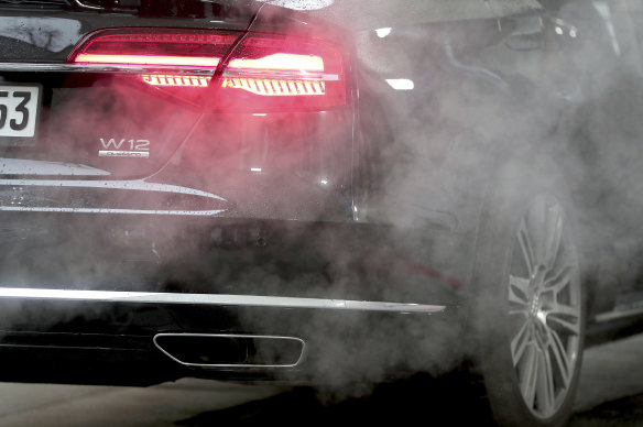 Gases rise from the exhaust pipe of a luxury Audi parked with the engine running outside de Chancellery in Berlin.