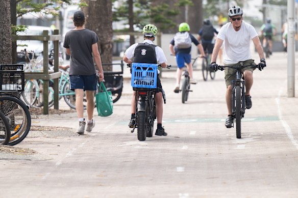 A rider on a fat-tyre e-bike (left), alongside other cyclists in Manly. 