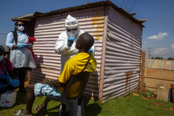 Health workers collect samples for coronavirus testing outside a shack to combat the spread of COVID-19 at Lenasia South, South Johannesburg, South Africa.