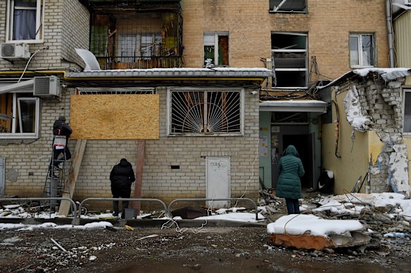 Residents inspect a building damaged by an air strike in Kharkiv, Ukraine. 